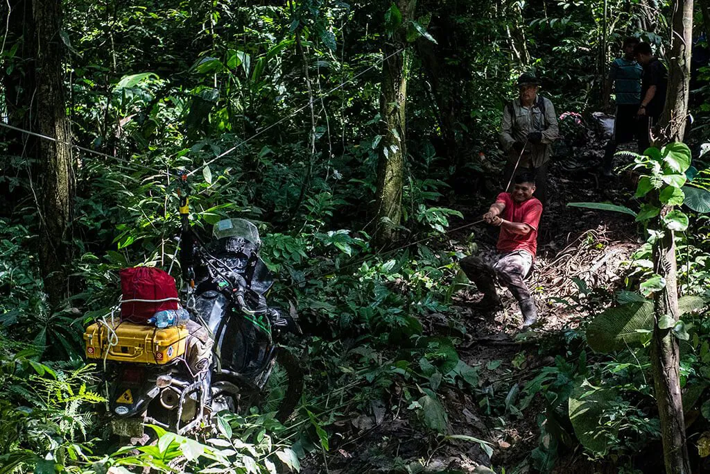 Hoisting motorcycle across water in Darien Gap